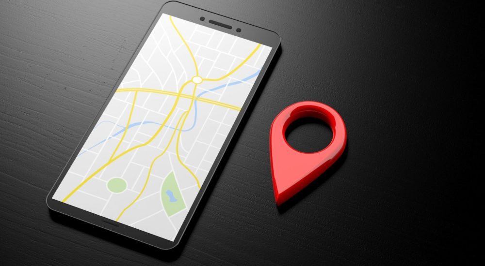 Navigation with a smartphone. Map on a smartphone screen and red location symbol on a black background, banner, copy space. 3d illustration