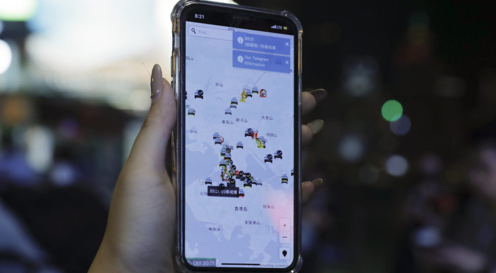 A person's phone shows HKmap.live apps as they join others at a rally to mark Taiwan's National Day, in the Tsim Sha Tsui district in Hong Kong, Thursday, Oct. 10, 2019.  A Hong Kong government official said on Thursday that Apple was responsible for removing a smartphone application which allowed activists to report police movements. (AP Photo/Kin Cheung)