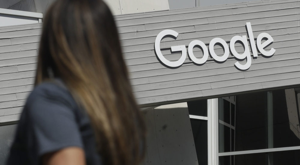 A woman walks below a Google sign on the campus in Mountain View, Calif., Tuesday, Sept. 24, 2019. (AP Photo/Jeff Chiu)
