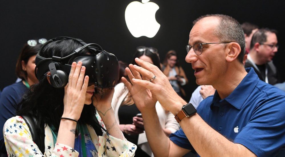 An Apple employee helps a member of the media try on an HTC Vive while testing the virtual reality capabilities of the new iMac during Apple's Worldwide Developers Conference in San Jose, California on June 5, 2017. / AFP PHOTO / Josh Edelson        (Photo credit should read JOSH EDELSON/AFP via Getty Images)