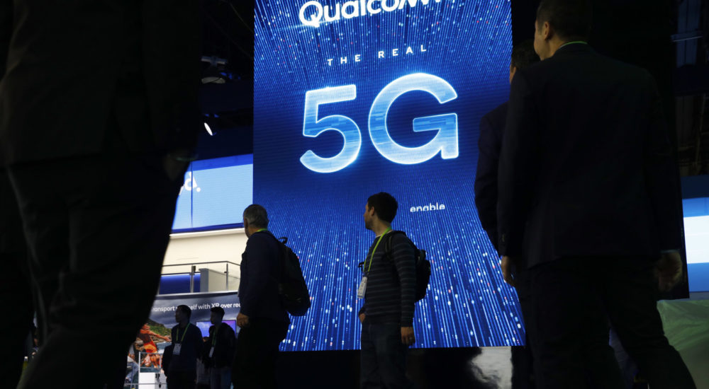 FILE- In this Jan. 9, 2019, file photo a sign advertises 5G at the Qualcomm booth at CES International in Las Vegas. Qualcomm and Apple drove declines in technology stocks on Wednesday, May 22. Qualcomm plunged following a federal judge's ruling against the chipmaker in an antitrust case. (AP Photo/John Locher, File)