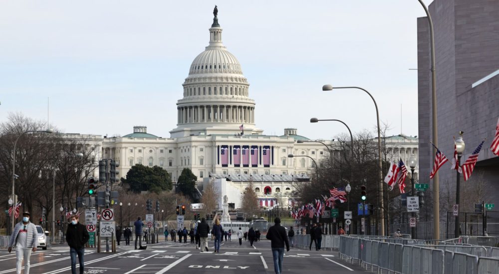 WASHINGTON, DC - JANUARY 16: Pedestrians walk along Pennsylvania Avenue near the U.S. Capitol on January 16, 2021 in Washington, DC. After last week's riots at the U.S. Capitol Building, the FBI has warned of additional threats in the nation's capital and in all 50 states. According to reports, as many as 25,000 National Guard soldiers will be guarding the city as preparations are made for the inauguration of Joe Biden as the 46th U.S. President. (Photo by Michael M. Santiago/Getty Images)